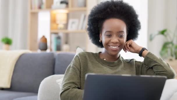 Nevetés afro nő streaming online filmek segítségével laptop nézni vicces vígjáték filmek segítségével előfizetés. Mosolygó, boldog nő ül egyedül otthon nappali kanapén, pihentető és a technológia használata. - Felvétel, videó