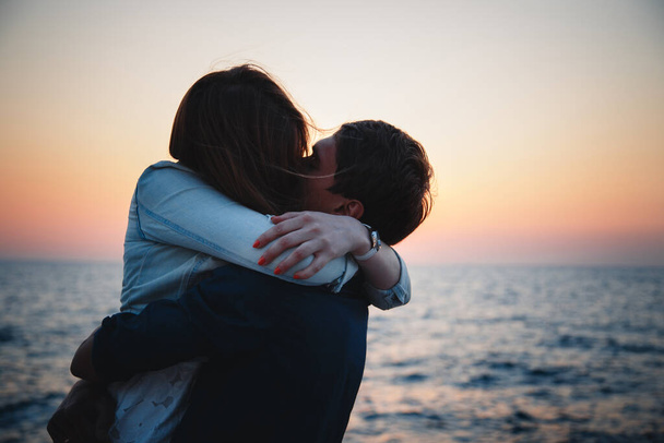 Close up of young couple hugging at sunrise beach background, summer time. - Foto, immagini