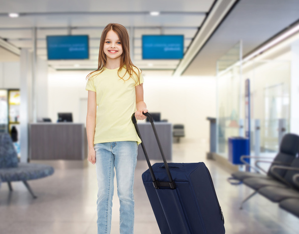 smiling girl with travel bag in airport - Foto, imagen