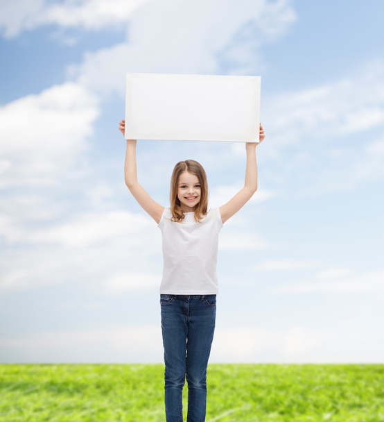 smiling little girl holding blank white board - Фото, зображення