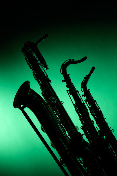 Saxofones em silhueta contra verde
 - Foto, Imagem