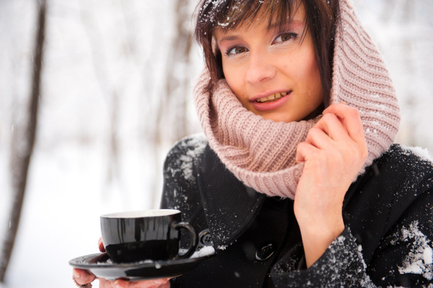 Portrait of young beautiful woman standing alone in winter park - Foto, Imagem