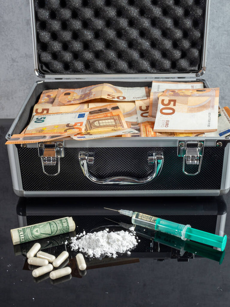 Money and drugs on a black glass table. Money, syringe and drugs. - Fotografie, Obrázek