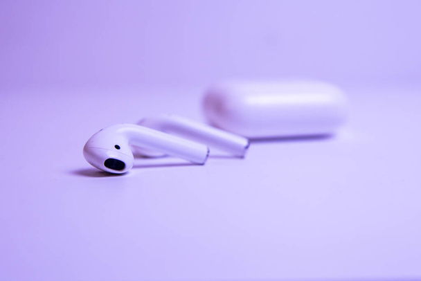 wireless headphones with a case in neon light. - 写真・画像