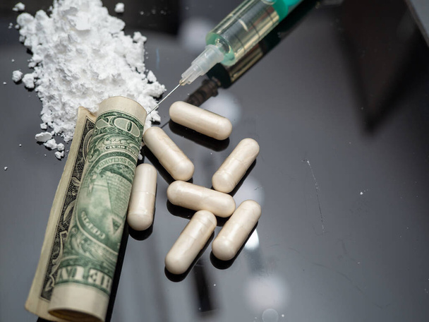 Money and drugs on a black glass table. Money, syringe and drugs. - Foto, Imagem