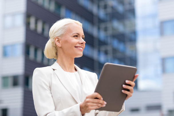 smiling businesswoman with tablet pc outdoors - Photo, image