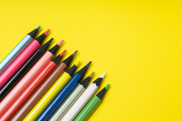 colored pencils on a yellow background. High quality photo - Zdjęcie, obraz