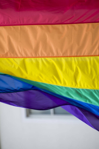 Lähikuva sateenkaari homo ylpeys lippu ulkona kadulla. Symboli Lesbo Biseksuaali Transsukupuolinen LGBT yhteisö vilkuttaa tuulessa vastaan pilvinen taivas. Sosiaalinen liikkuvuus vapauden ja tasa-arvon puolesta. Kopioi tila  - Valokuva, kuva