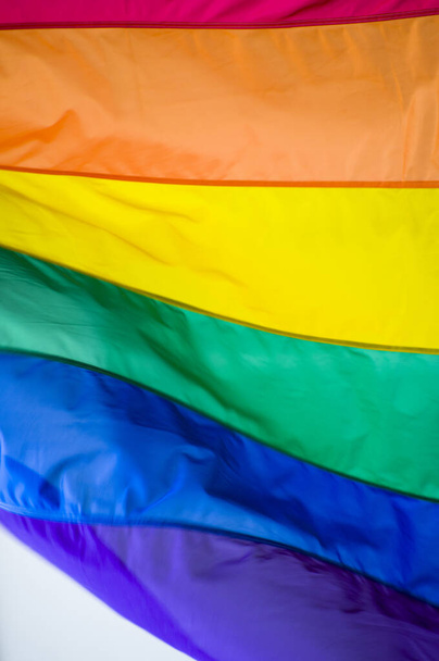 zbliżenie tęcza gej duma flaga na zewnątrz na ulica. Symbol społeczności lesbijskich transseksualistów LGBT falujących na wietrze przed pochmurnym niebem. Ruch społeczny na rzecz wolności i równości. Przestrzeń kopiowania  - Zdjęcie, obraz