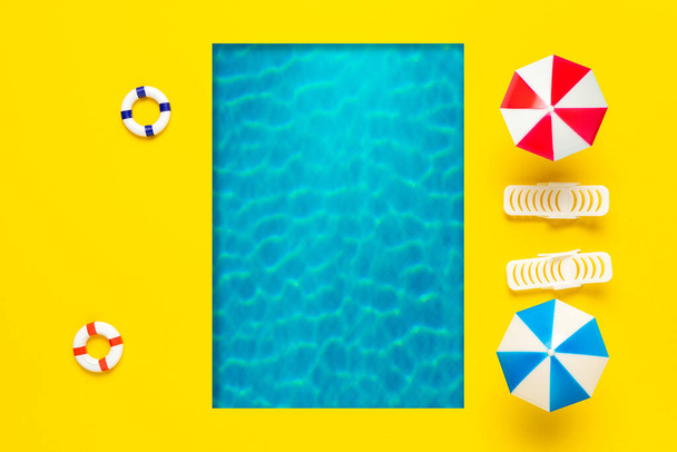 Summer scene with swimming pool, sun umbrella and sunbed. Minimal summer holiday concept background. Tropical party top view. - Fotografie, Obrázek