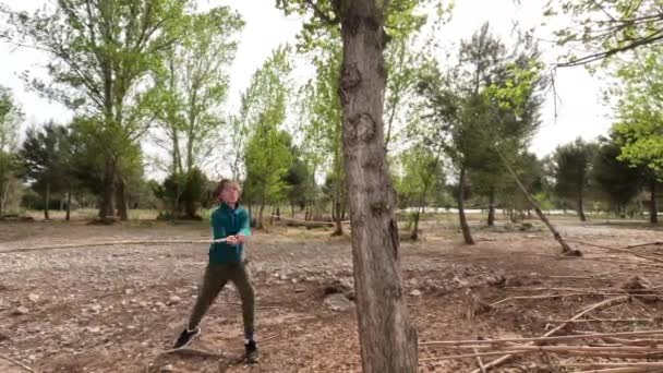 Teenage boy letting steam off and breaking a wooden stick against the tree in the woods. Rebellious age - Záběry, video