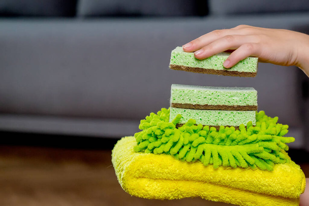 Colored rags and washcloths for manual cleaning on a woman's hand. House cleaning. - 写真・画像