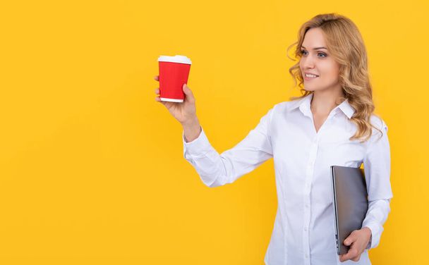 happy blonde woman with coffee cup and computer on yellow background. - Foto, Imagem
