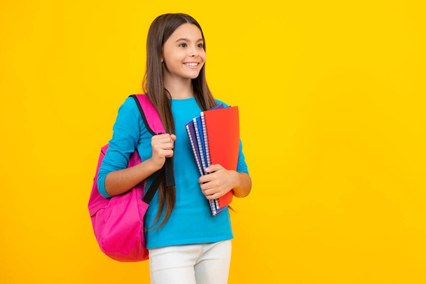 Happy teenager portrait. School teenager child girl 12, 13, 14 years old with book and copybook. Teenager schoolgirl on isolated background. Learning and knowledge education concept. Smiling girl - Foto, imagen