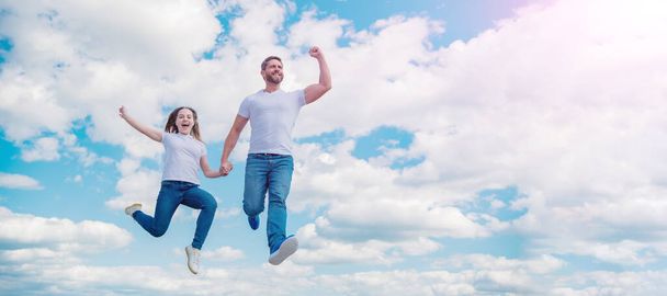 Батько і дочка стрибають на небо, банер з копіювальним простором. щасливий батько і дочка стрибають у небо. підтримка сім'ї
. - Фото, зображення