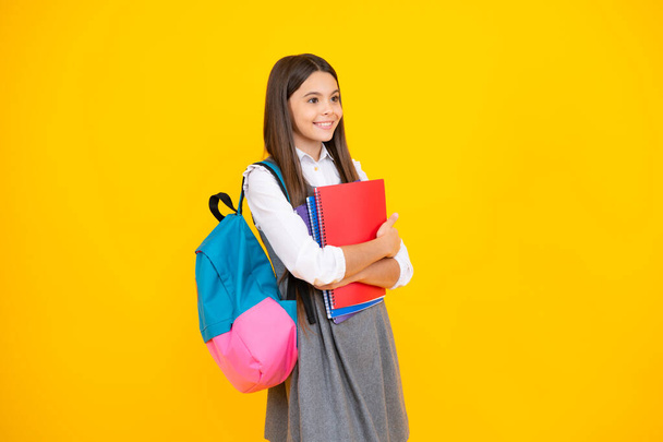 Un écolier, une étudiante adolescente tient un livre sur un fond de studio isolé jaune. Concept scolaire et éducatif. Retour à l'école - Photo, image