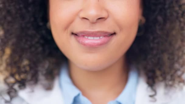 Happy female pharmacist smiling and looking cheerful. Closeup mouth of joyful african medical worker with an afro showing her teeth. A friendly and cute chemist working in a pharmacy or drugstore. - Filmagem, Vídeo
