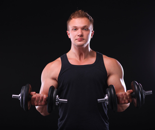 Handsome muscular man working out with dumbbells - Foto, afbeelding