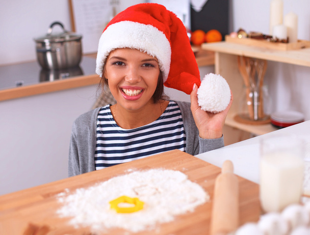 Happy young woman smiling happy having fun with Christmas preparations wearing Santa hat - Foto, Bild