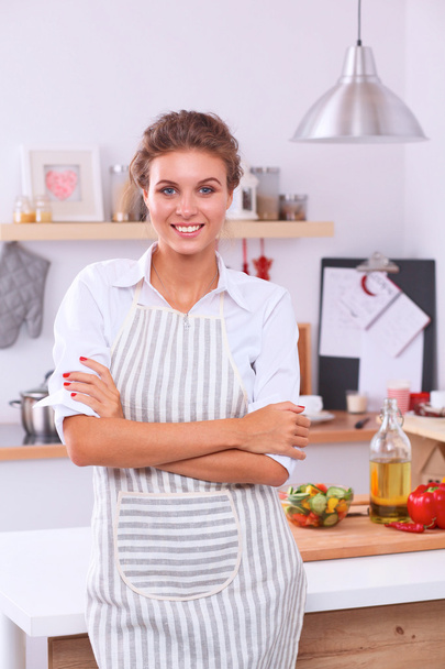 Smiling young woman in the kitchen, isolated on christmas background - Фото, зображення