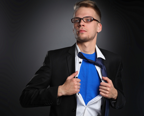 Mladý podnikatel jednající jako super hrdina a trhání košili, izolované na šedém pozadí - Fotografie, Obrázek