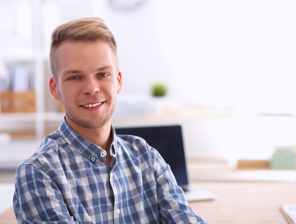 Young businessman working in office, sitting at desk - Foto, Bild