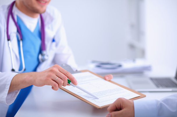 Doctor male giving patient folder with  paper in her office, isolated - Photo, image