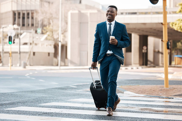 Ready to take the trip of a lifetime. a young businessman drinking coffee while walking to the airport - Fotó, kép