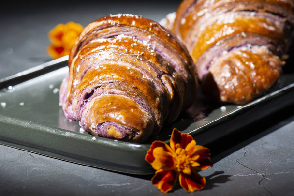 Fresh baked home made Ube Croissants using flavouring and purple yam powder and three book folds, lightly sprinkled with coconut. - Foto, Imagen
