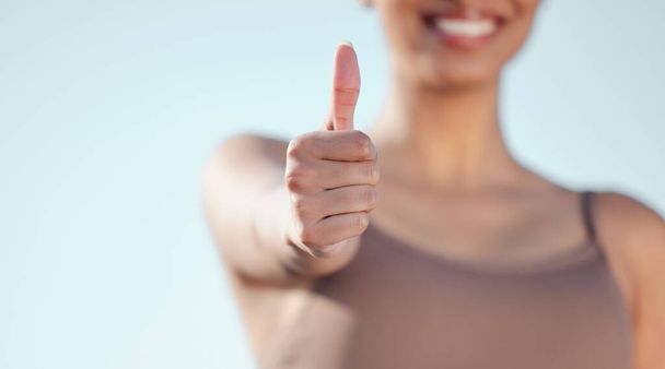 Just go for it. Closeup shot of an unrecognisable woman showing thumbs up while exercising outdoors - Фото, изображение