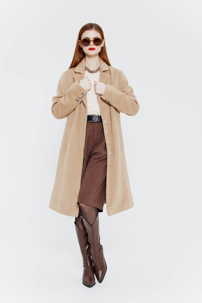 A red-haired lady in a coat on a white background. Full-length shot. High quality photo - Photo, Image