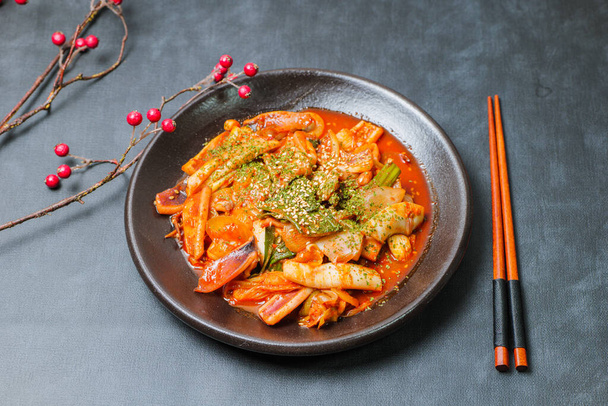 Korean food Stir-fried Squid, ojingeobokkeum : Squid stir-fried with onions, carrots, and cabbage in a spicy mixture of gochujang and red chili powder. - Foto, Imagen