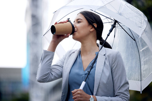 My body is thanking me. a young businesswoman enjoying a cup of coffee in the rain - Fotografie, Obrázek