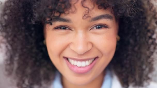Happy female pharmacist smiling and looking cheerful. Closeup face of joyful african medical worker with afro standing inside. Head portrait of a friendly and cute chemist working in a pharmacy. - Filmagem, Vídeo
