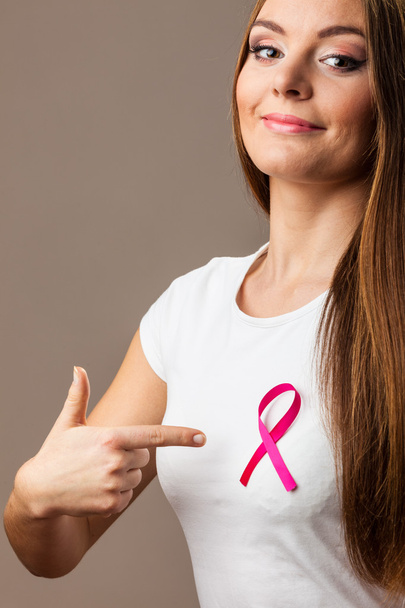 Woman  with pink cancer ribbon pointing - Photo, image