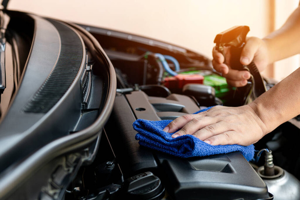 Samochód czyste pojęcie, Ręka człowieka trzymającego mikrofibry i spray czyszczenia silnika pokój samochodu po myjni samochodowej dla czystości i konserwacji samochodu  - Zdjęcie, obraz