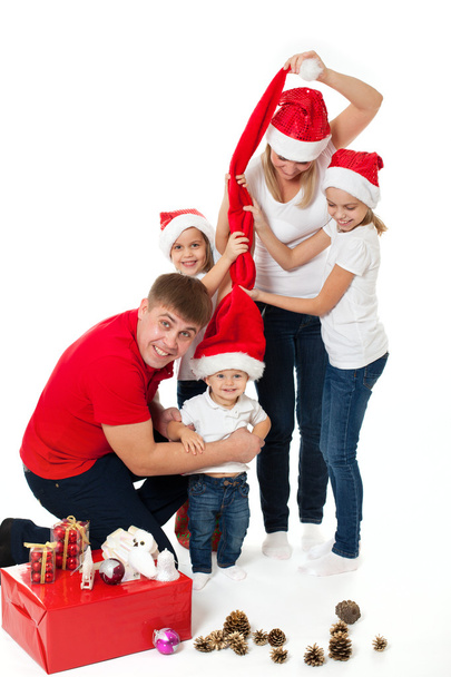 Happy cute family of three children and parents in santa's hats - Фото, изображение