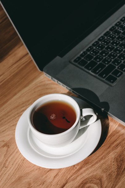 Cup of tea and laptop - Фото, изображение