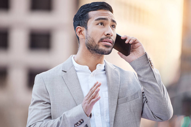 Can I go ahead with the deal. a handsome young businessman standing in the city and using his cellphone - 写真・画像