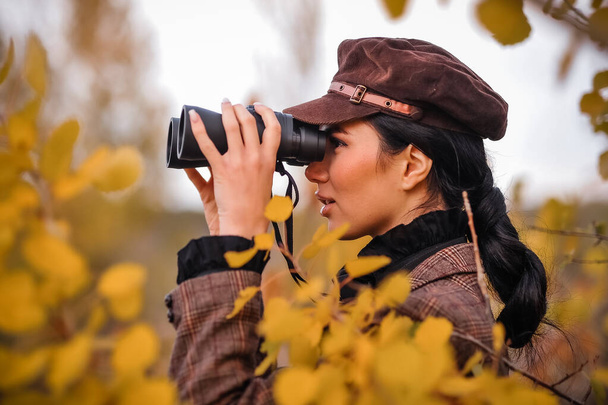 young woman with binoculars in autumn park - Foto, imagen