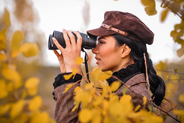 молодая женщина с камерой в осеннем парке - Фото, изображение