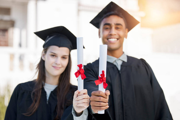 Our ticket to success is here. Portrait of a young man and woman celebrating with their diplomas on graduation day - Foto, imagen