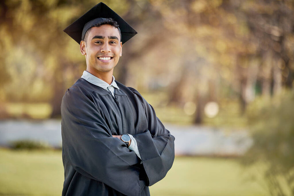 I made it despite all circumstance. Portrait of a young man standing with his arms crossed on graduation day - 写真・画像