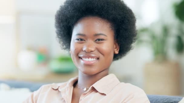 Happy African woman with an afro laughing and giggling at home. Face portrait of a beautiful black female, showing her perfect teeth and smile. Young student or entrepreneur enjoying free time. - Кадры, видео