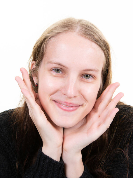 Portrait of young pretty positive girl smiling looking at camera two palm hands fingers on chin over white background - Foto, Imagem