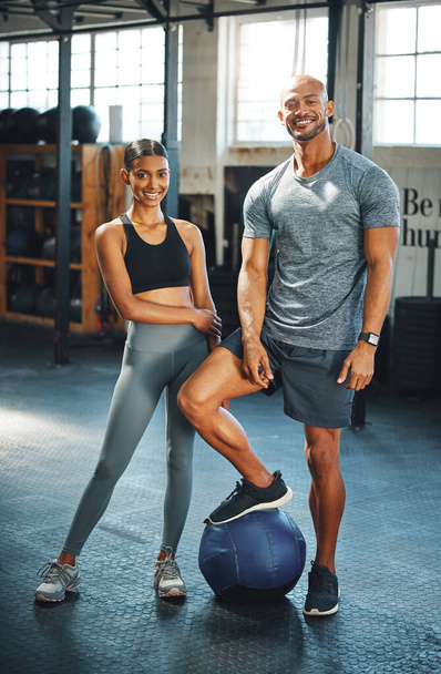 Were proof for what hard work can do. Portrait of a sporty young man and woman standing together in a gym - Foto, immagini