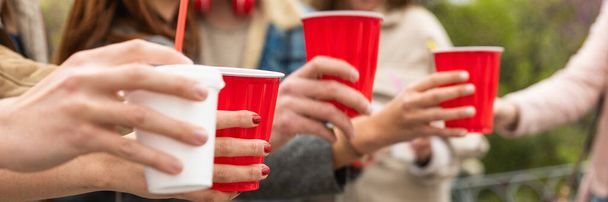 Happy diverse young people having fun delivery drink - Happy friends drinking and toasting from disposable paper cup - banner size for header design - Foto, Imagen