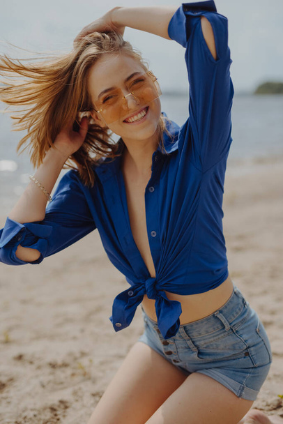 Happy funny young woman smiling sitting on the beach - Фото, зображення
