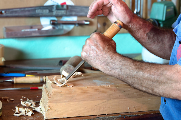 Cabinetmaker esculpir um pedaço de madeira com cinzel e usando seu h
 - Foto, Imagem