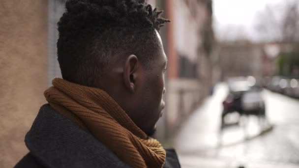 Huolestunut musta mies seisoo kaupungin ulkopuolella, lähikuva kasvot muotokuva huomaavainen ilme - Materiaali, video